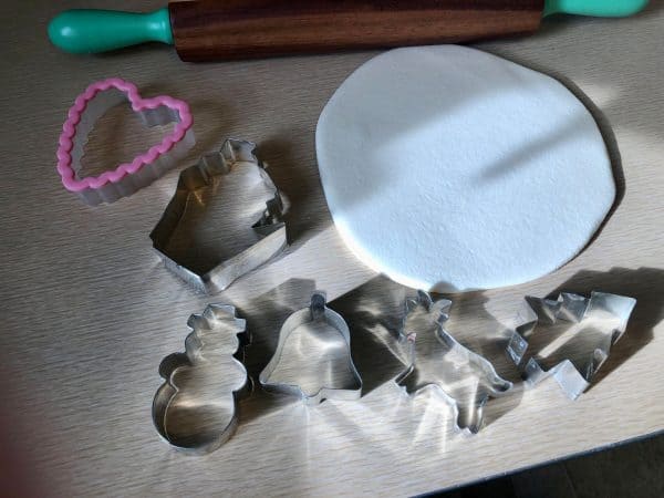 Christmas cookie cutters. State of Wisconsin cookie cutter. Snowman cookie cutter. Goat cookie cutter. Christmas tree cookie cutter. Heart cookie cutter. Bell cookie cutter. Salt Dough Ornament rolled out with rolling pin for Salt Dough Ornament DIY.