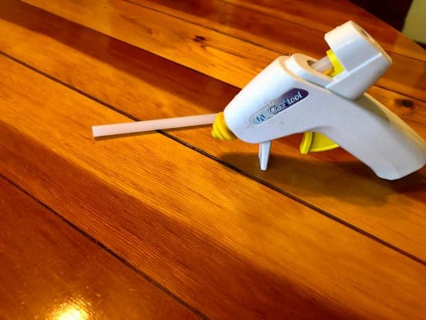 Hot glue gun for personalized Christmas ornament punch needle project.