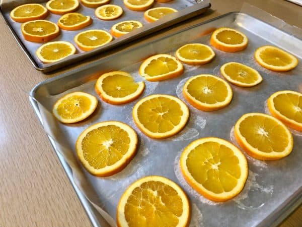 Orange slices on lined cookie sheets. Dried Orange Garland DIY. DIY crafts for Christmas. Holiday crafts. Homemade garland.  Holiday decor. Christmas decor.