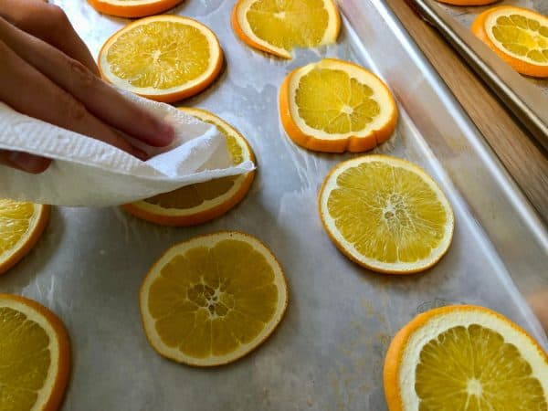 Orange slices on lined cookie sheets. Dried Orange Garland DIY. DIY crafts for Christmas. Holiday crafts. Homemade garland.  Holiday decor. Christmas decor.
