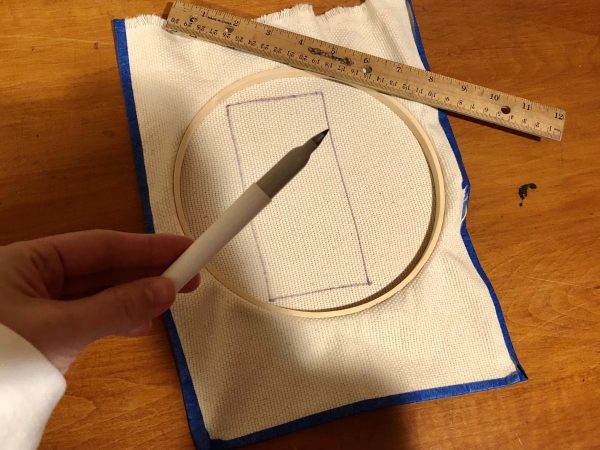 Steps for adorable DIY phone pad made by a punch needle with acrylic yarn.  Punch needle. Punch needle kit. Embroidery Hoop. Monks cloth. Fabric Scissors. Grey, Yellow, and White color scheme. Yarn crafts. Punch needle projects. Phone holder on desk. DIY phone holder.