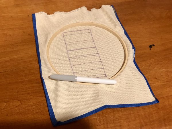 Steps for adorable DIY phone pad made by a punch needle with acrylic yarn.  Punch needle. Punch needle kit. Embroidery Hoop. Monks cloth. Fabric Scissors. Grey, Yellow, and White color scheme. Yarn crafts. Punch needle projects. Phone holder on desk. DIY phone holder.