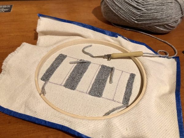 Steps for adorable DIY phone pad made by a punch needle with acrylic yarn.  Punch needle. Punch needle kit. Embroidery Hoop. Monks cloth. Fabric Scissors. Grey, Yellow, and White color scheme. Yarn crafts. Punch needle projects. Phone holder on desk. DIY phone holder.