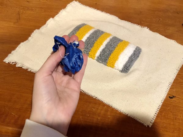 Steps for adorable DIY phone pad made by a punch needle with acrylic yarn.  Punch needle. Punch needle kit. Embroidery Hoop. Monks cloth. Fabric Scissors. Grey, Yellow, and White color scheme. Yarn crafts. Punch needle projects. Phone holder on desk. DIY phone holder.