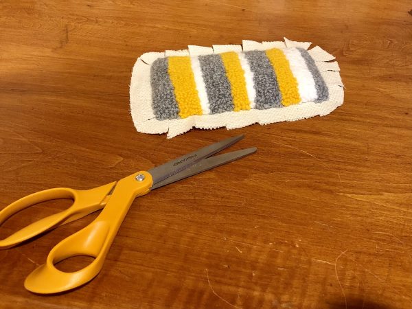 Steps for adorable DIY phone pad made by a punch needle with acrylic yarn.  Punch needle. Punch needle kit. Embroidery Hoop. Monks cloth. Fabric Scissors. Grey, Yellow, and White color scheme. Yarn crafts. Punch needle projects. Phone holder on desk. DIY phone holder.