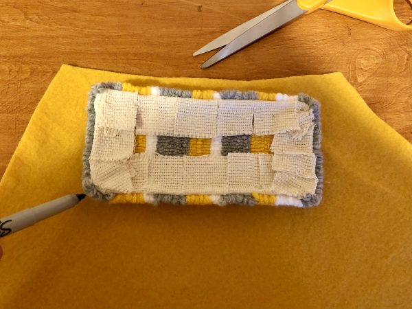 Steps for adorable DIY phone pad made by a punch needle with acrylic yarn.  Punch needle. Punch needle kit. Embroidery Hoop. Monks cloth. Fabric Scissors. Grey, Yellow, and White color scheme. Yarn crafts. Punch needle projects. Phone holder on desk. DIY phone holder.