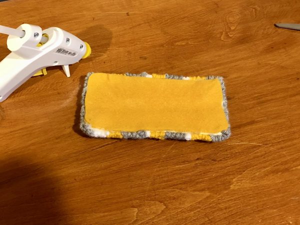 Steps for adorable DIY phone pad made by a punch needle with acrylic yarn.  Punch needle. Punch needle kit. Embroidery Hoop. Monks cloth. Fabric Scissors. Grey, Yellow, and White color scheme. Yarn crafts. Punch needle projects. Phone holder on desk. DIY phone holder.